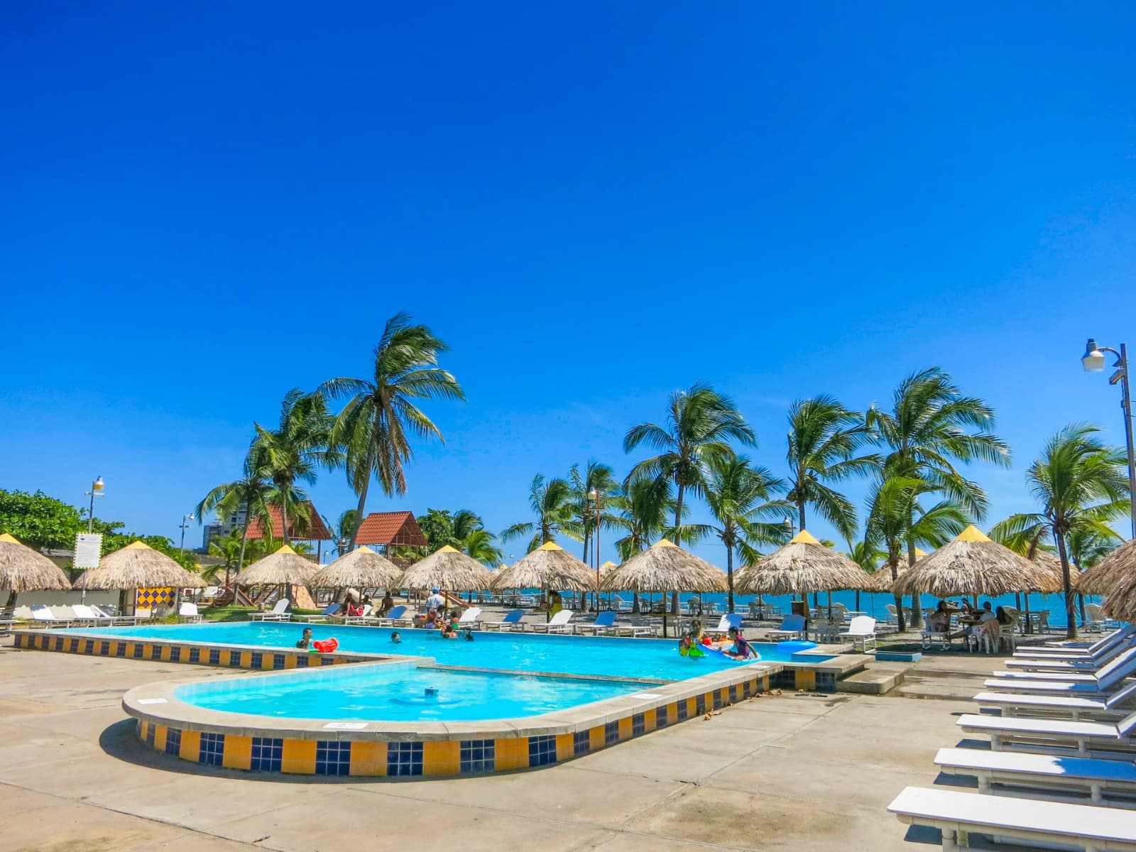 Piscina con palmeras y mar